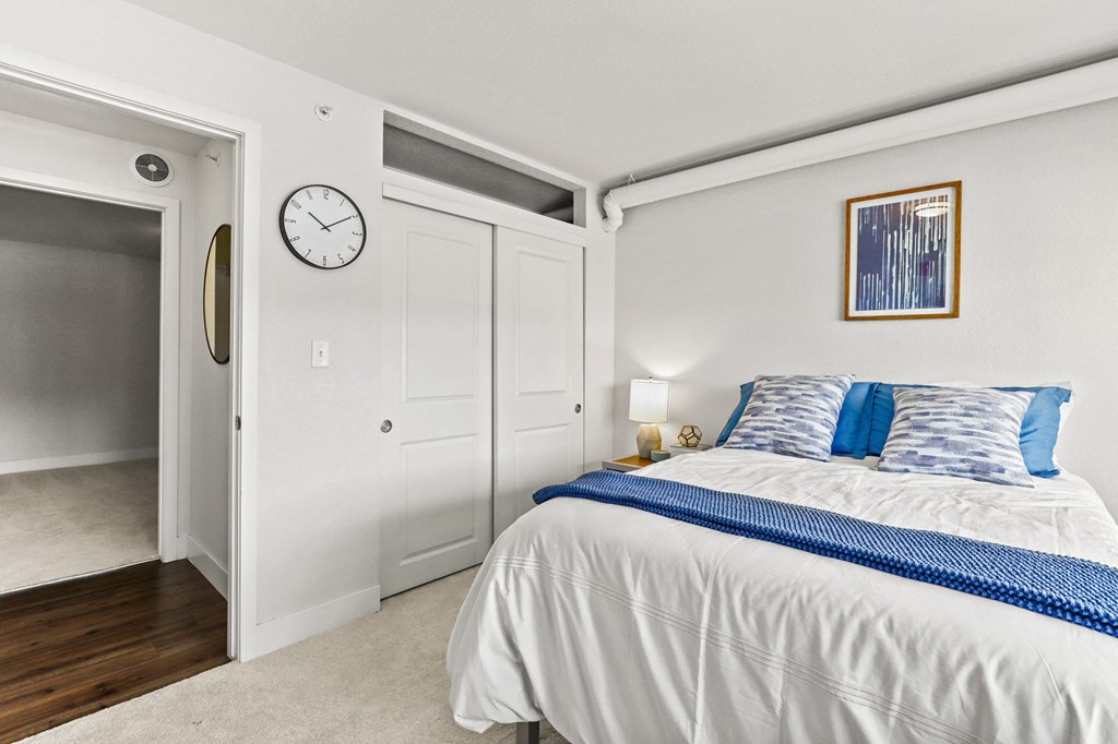 a bedroom with a bed and a clock on the wall