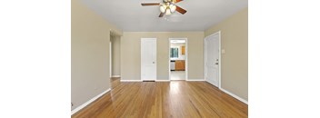 a living room with hardwood floors and a ceiling fan