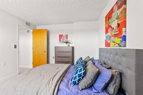 a bedroom with a bed with pillows and a dresser