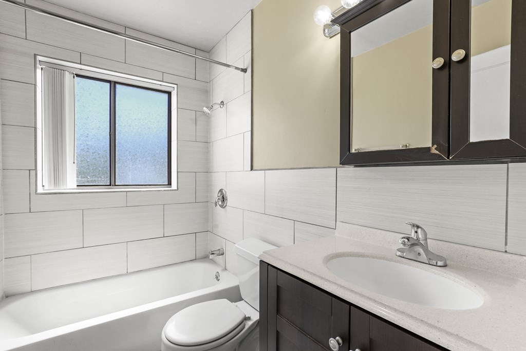 a bathroom with a sink toilet and tub and a mirror