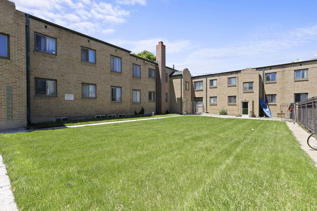 a grassy area in front of a brick building