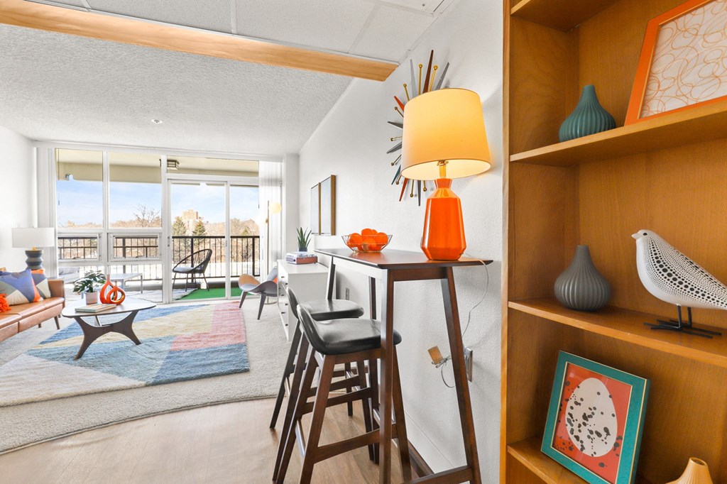 a living room with a bar and a view of the living room and a balcony