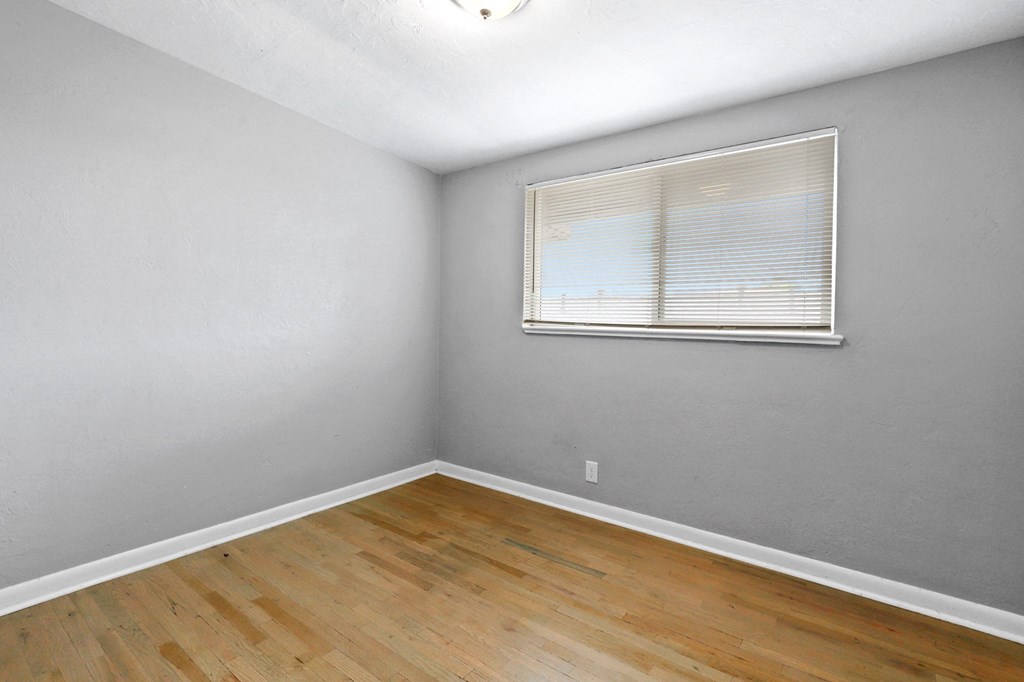 a bedroom with grey walls and a window