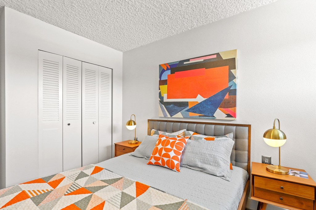 a bedroom with a bed and a painting on the wall