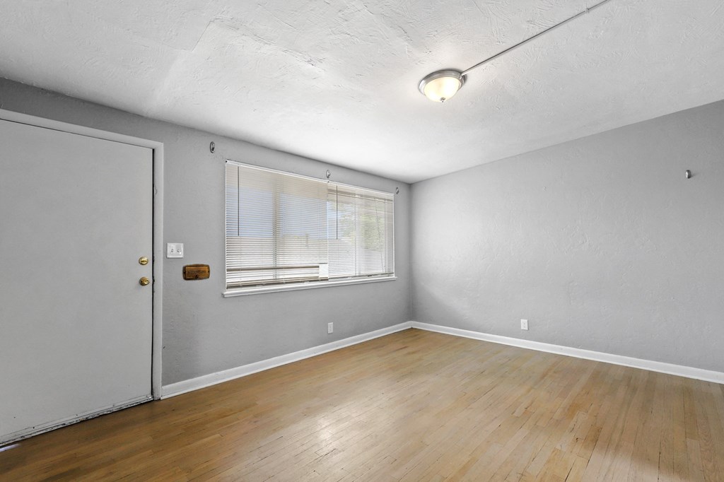 a bedroom with grey walls and hardwood floors
