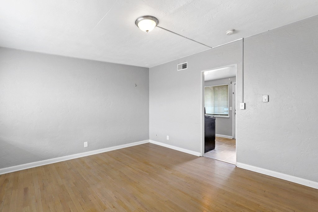 a bedroom with hardwood floors and grey walls