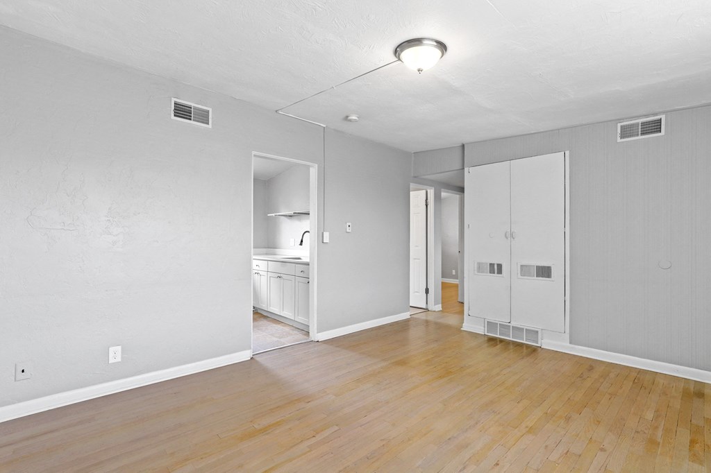 a bedroom with hardwood floors and grey walls