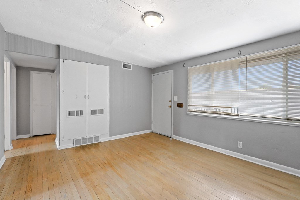 a living room with hardwood floors and grey walls