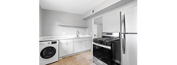 a kitchen with white cabinets and stainless steel appliances