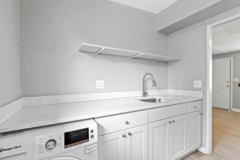 a kitchen with white cabinets and white appliances