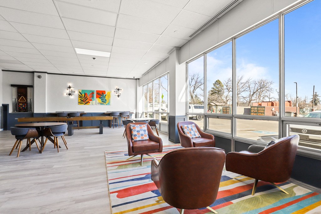 a lobby with chairs and tables and large windows