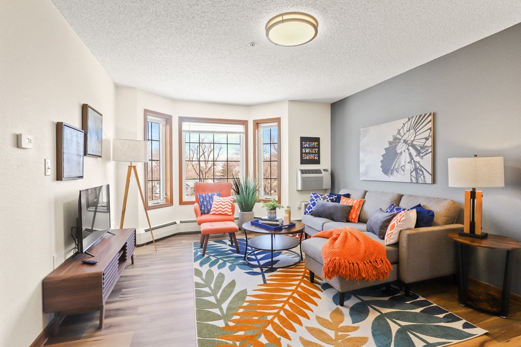 the living room of an apartment with a couch and a tv