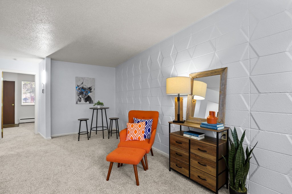 a living room with a chair and a dresser and a mirror