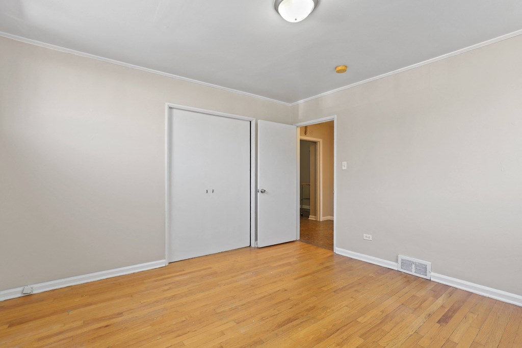 a living room with wood floors and a door to a hallway