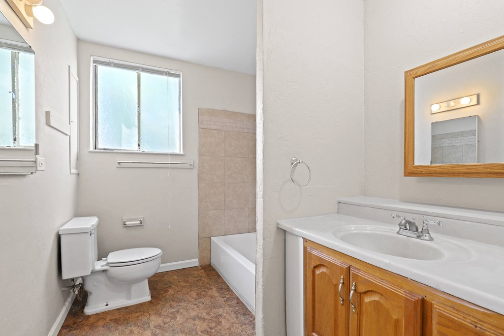 a bathroom with a toilet and a sink and a bath tub