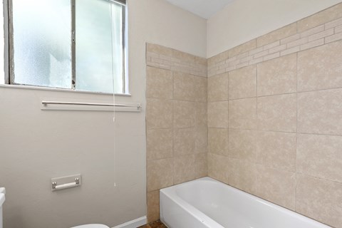 an empty bathroom with a tub and a window
