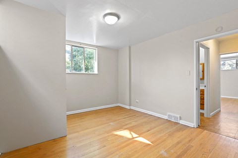 a living room with a hard wood floor and white walls