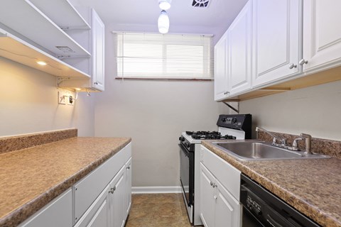 a kitchen with white cabinets and granite counter tops and a sink