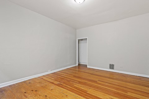 an empty room with wood flooring and white walls