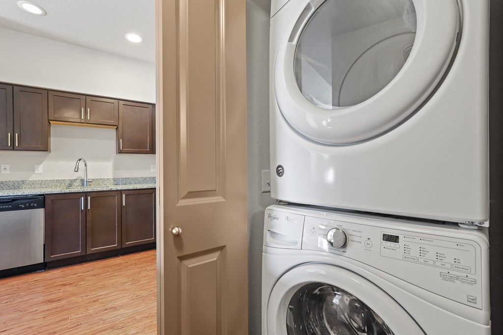 a washer and dryer in a laundry room with a door to the kitchen