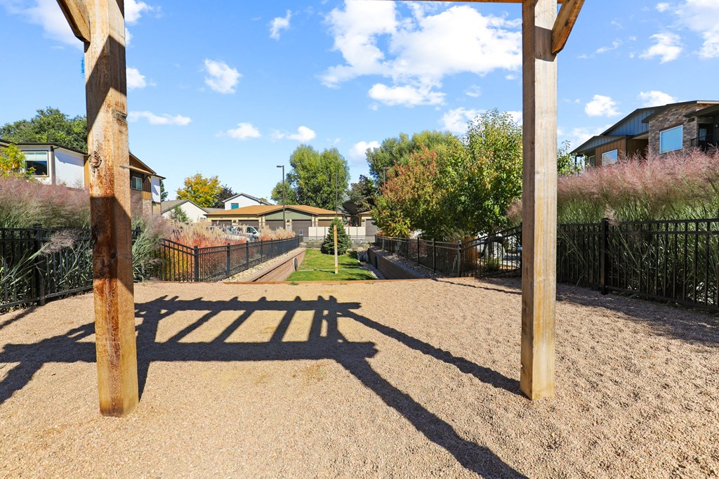 the backyard of a house with a sandy path and a fence