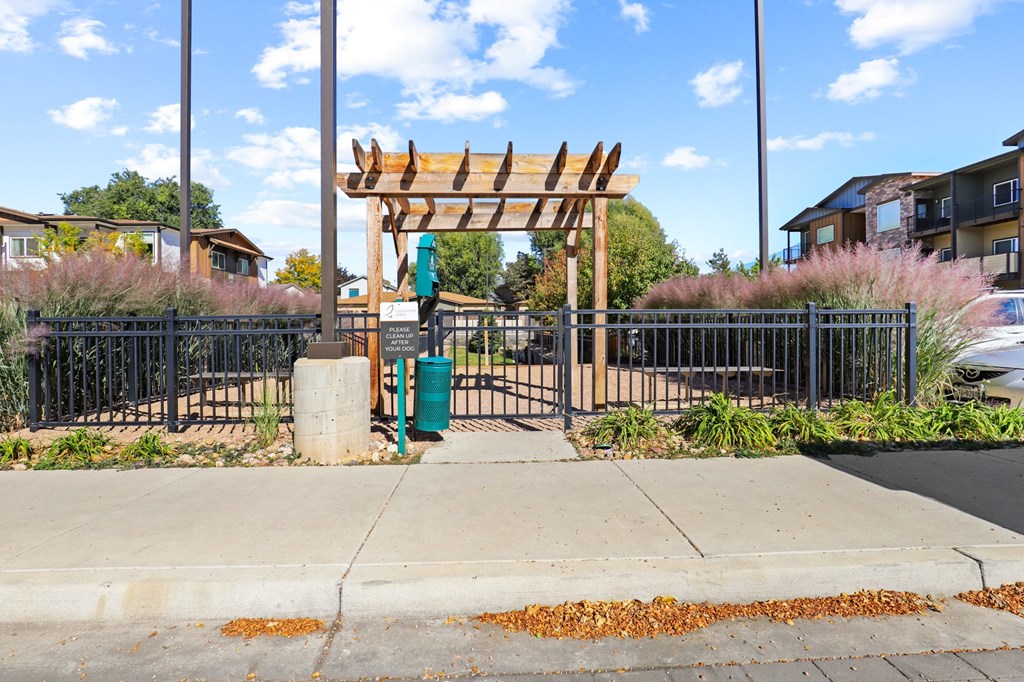 a gate with a wooden arch in front of a sidewalk