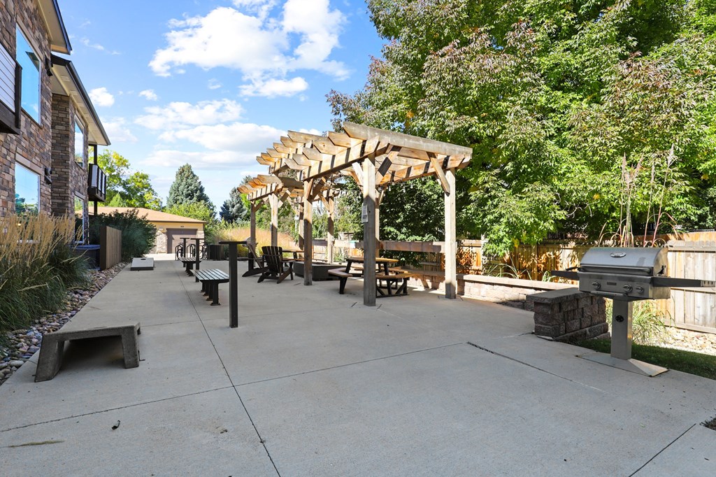 an outdoor patio with a grill and a pergola