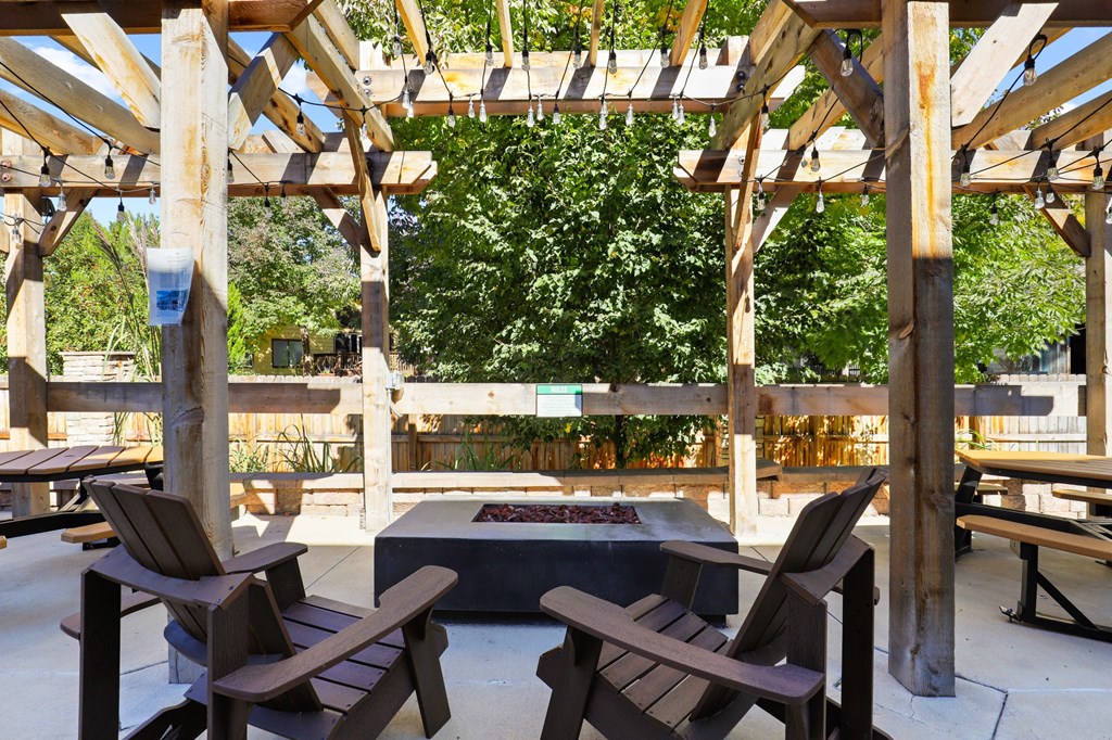 a patio with wooden chairs and a fire pit