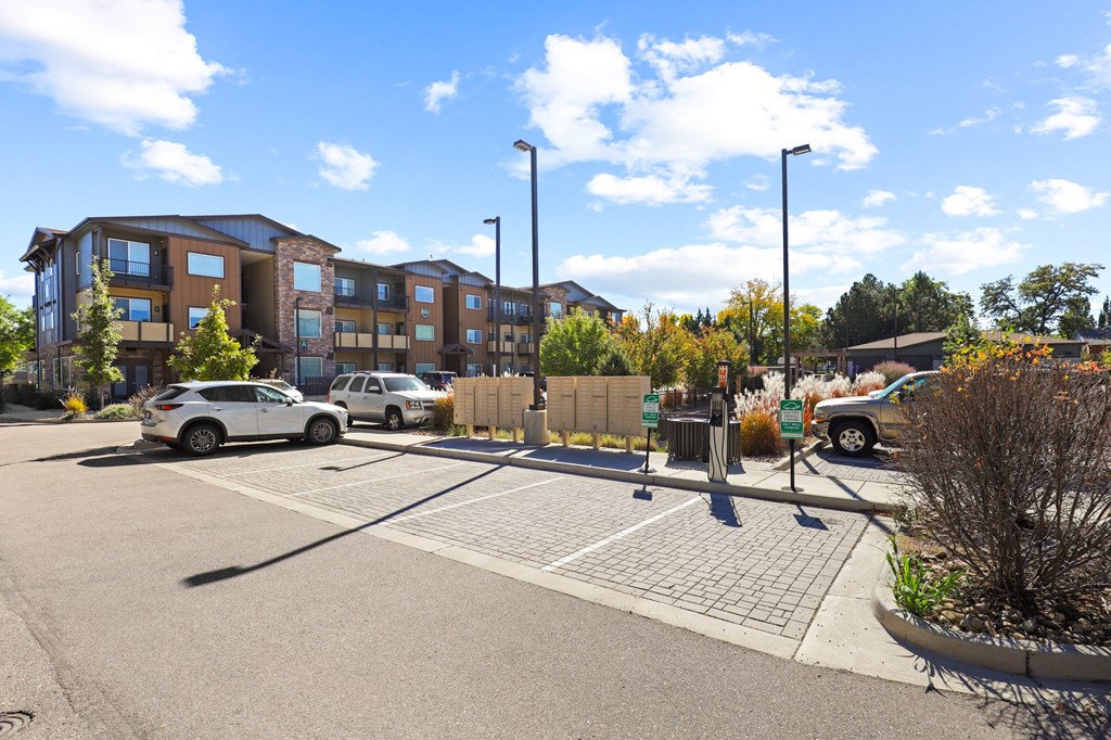 a parking lot with cars in front of an apartment building