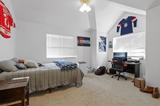 a bedroom with a bed and a desk and a computer
