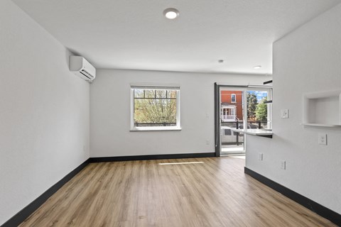 a living room with hardwood floors and white walls