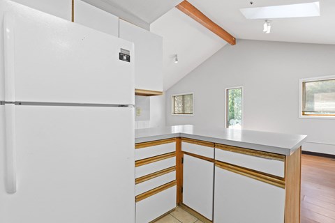 a kitchen with white cabinets and white countertops