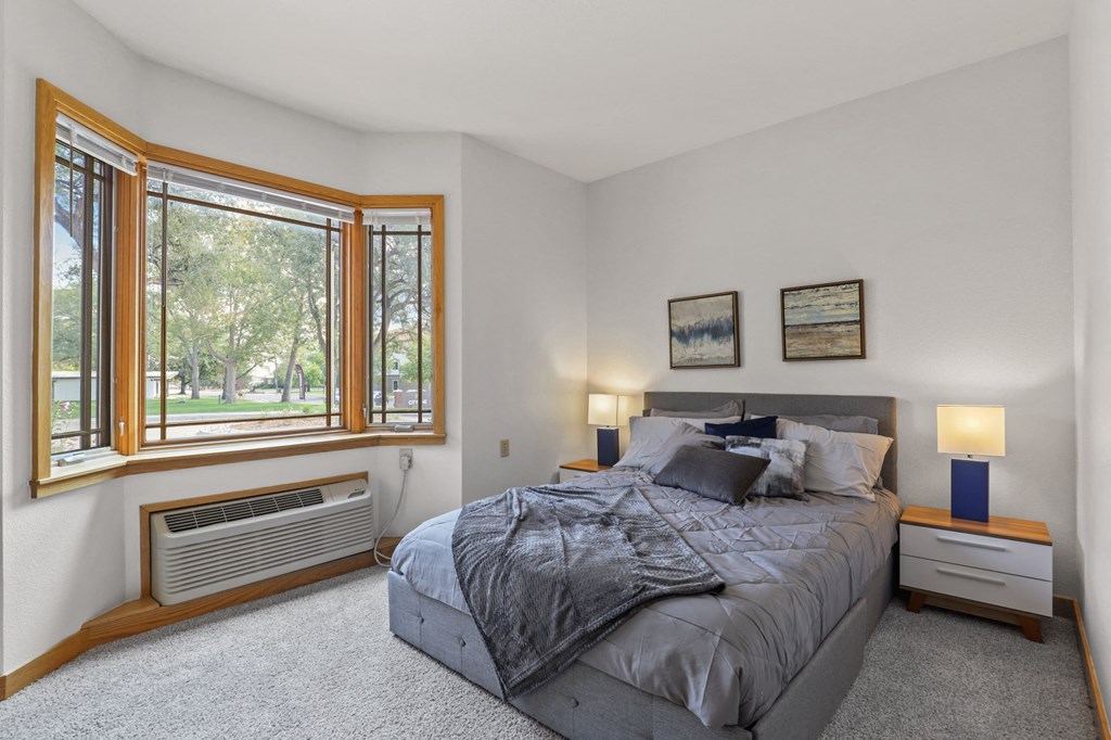 a bedroom with a bed and a large window