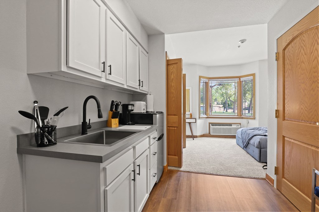 a kitchen with a sink and a door to a bedroom