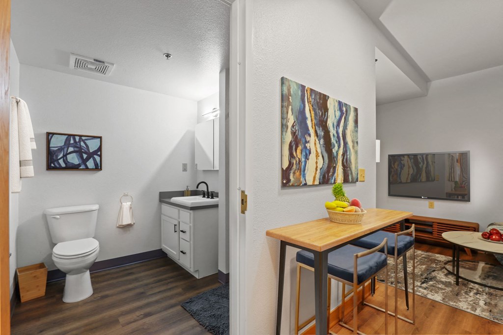 a bathroom with a sink and a toilet and a dining room table