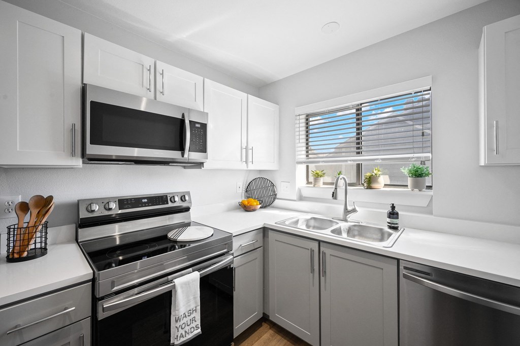 a modern kitchen with stainless steel appliances and white cabinets
