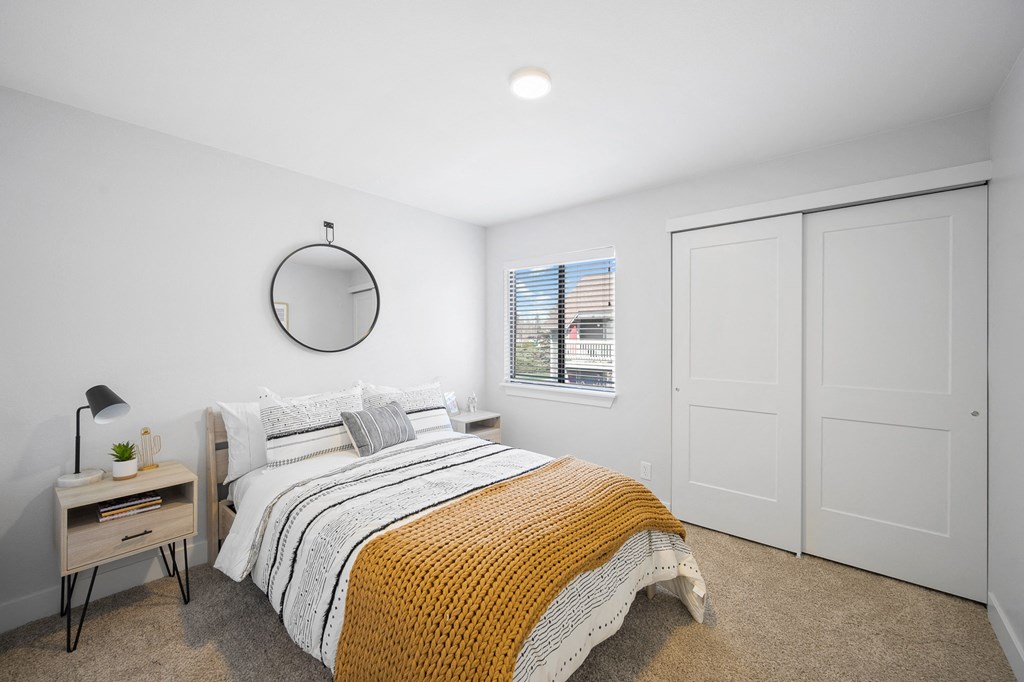 a bedroom with white walls and a bed with a yellow blanket