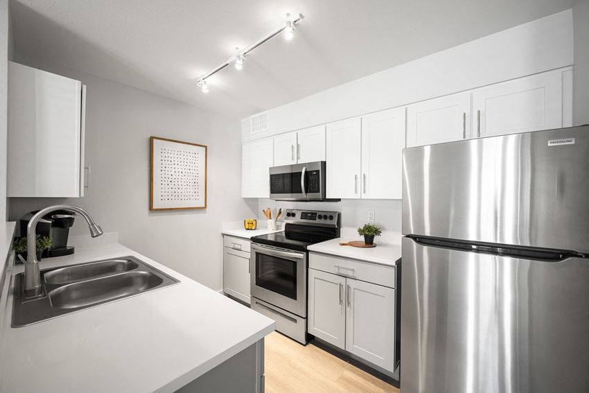 a kitchen with stainless steel appliances and white cabinets