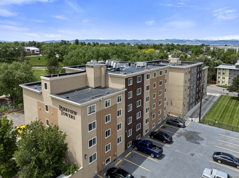 A parking lot is in front of a multi-story building named Purview Towers.