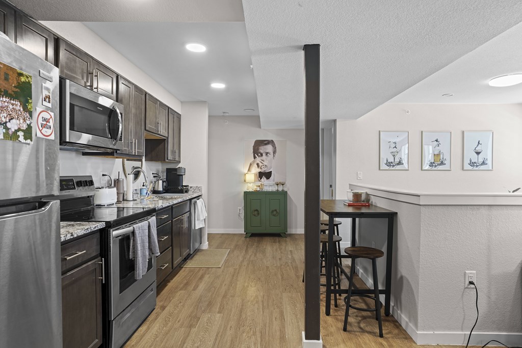 A woman is standing in a kitchen with a green cabinet.