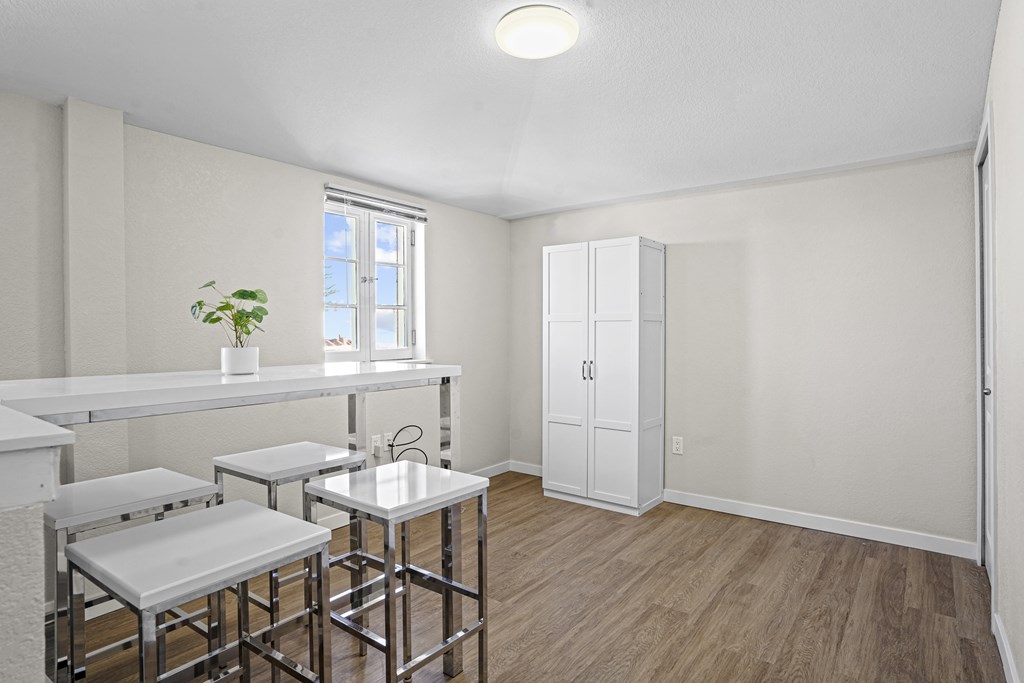 A white kitchen with a bar and stools.