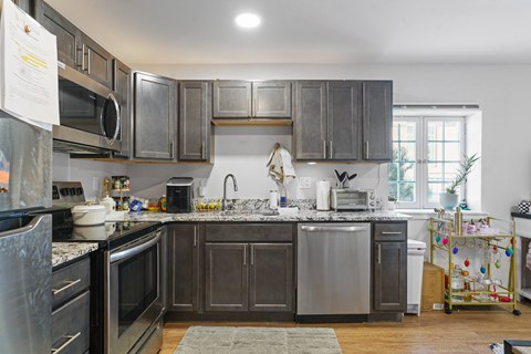 A kitchen with dark wood cabinets and stainless steel appliances.