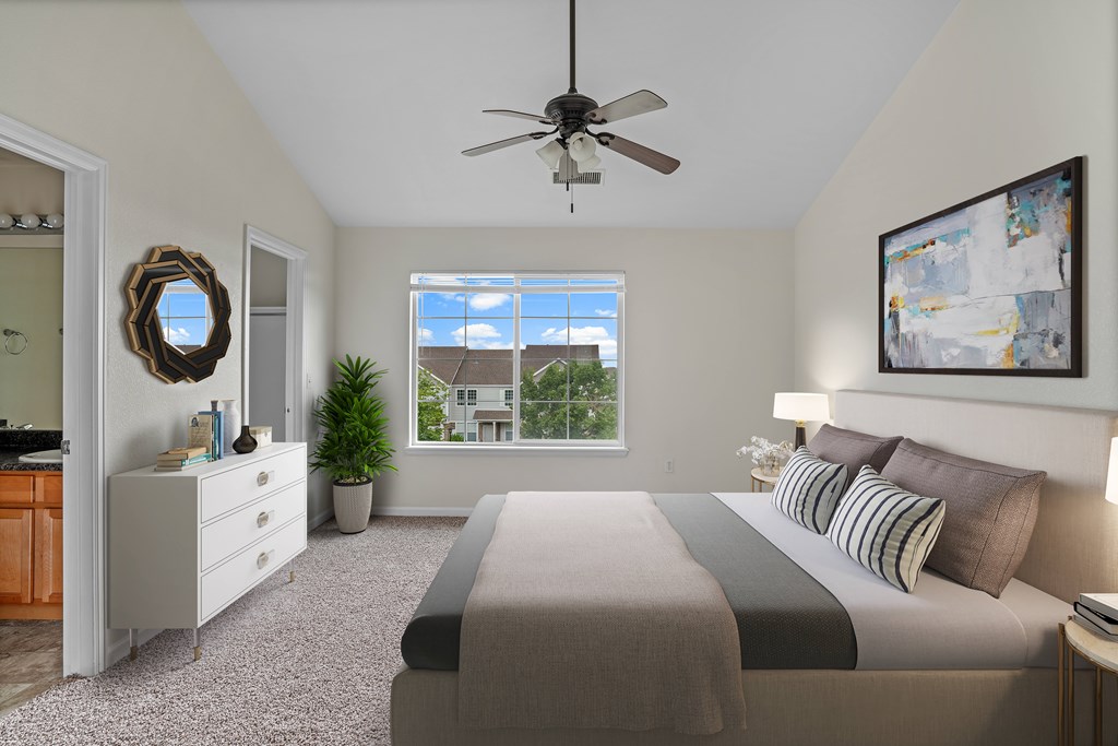 A bedroom with a large bed and a ceiling fan.