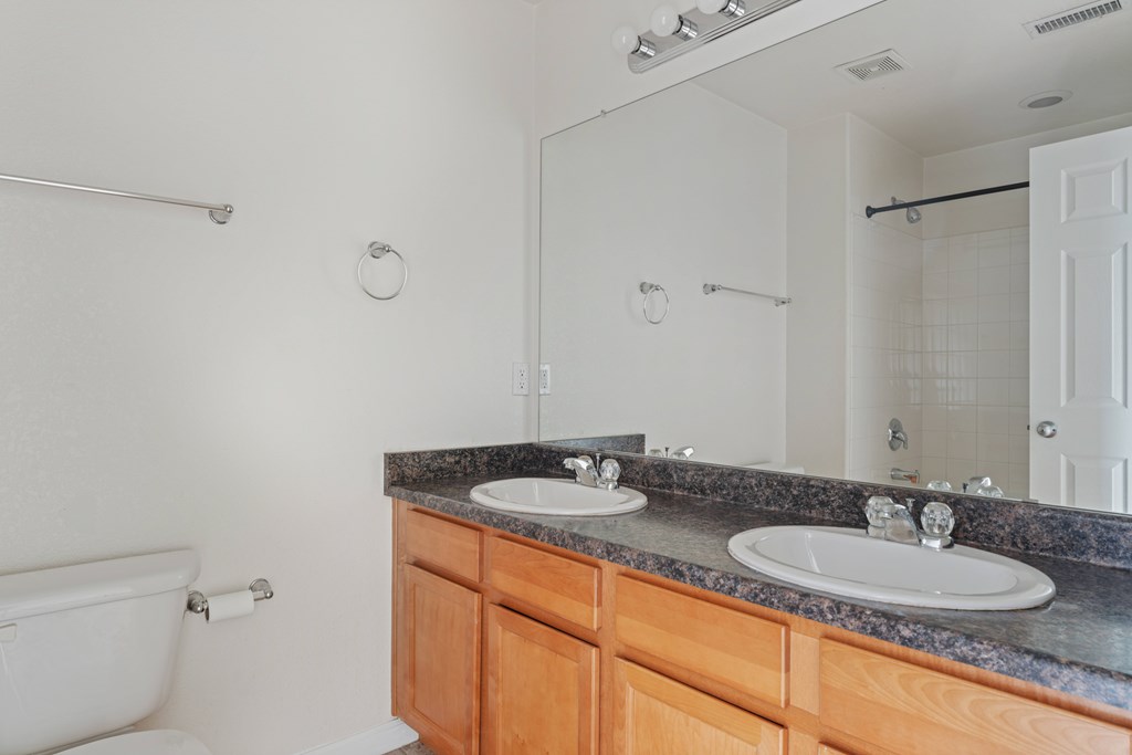 A white bathroom with a tub, sink, and mirror.