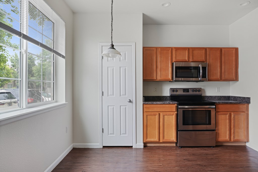 A kitchen with wooden cabinets and a black stove top oven.