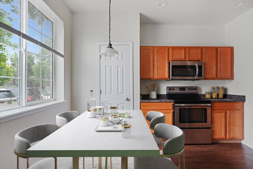 A modern kitchen with a dining table set for six.
