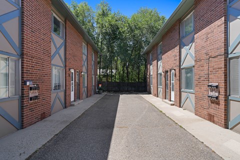 A long, narrow driveway leads between two rows of identical houses.
