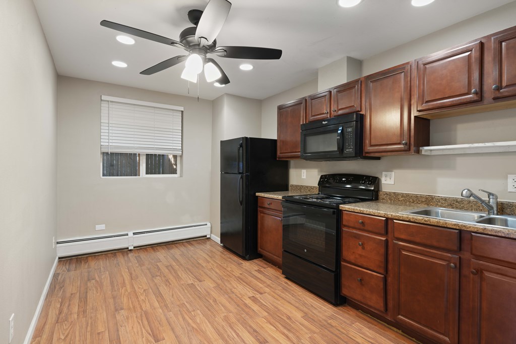 A kitchen with wooden cabinets and black appliances.