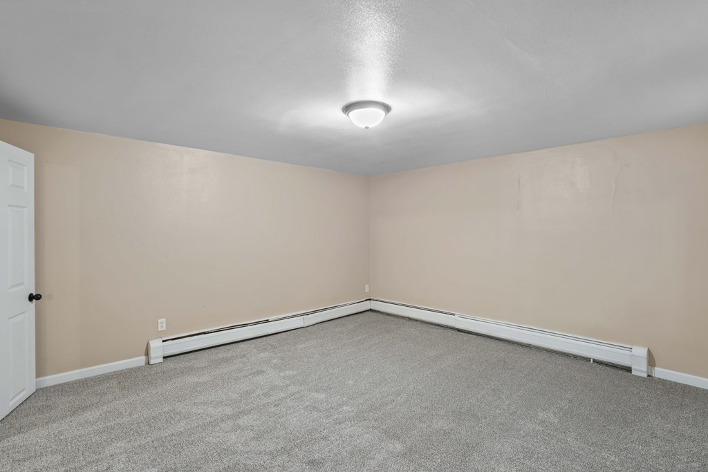 A room with a carpeted floor and a white door.