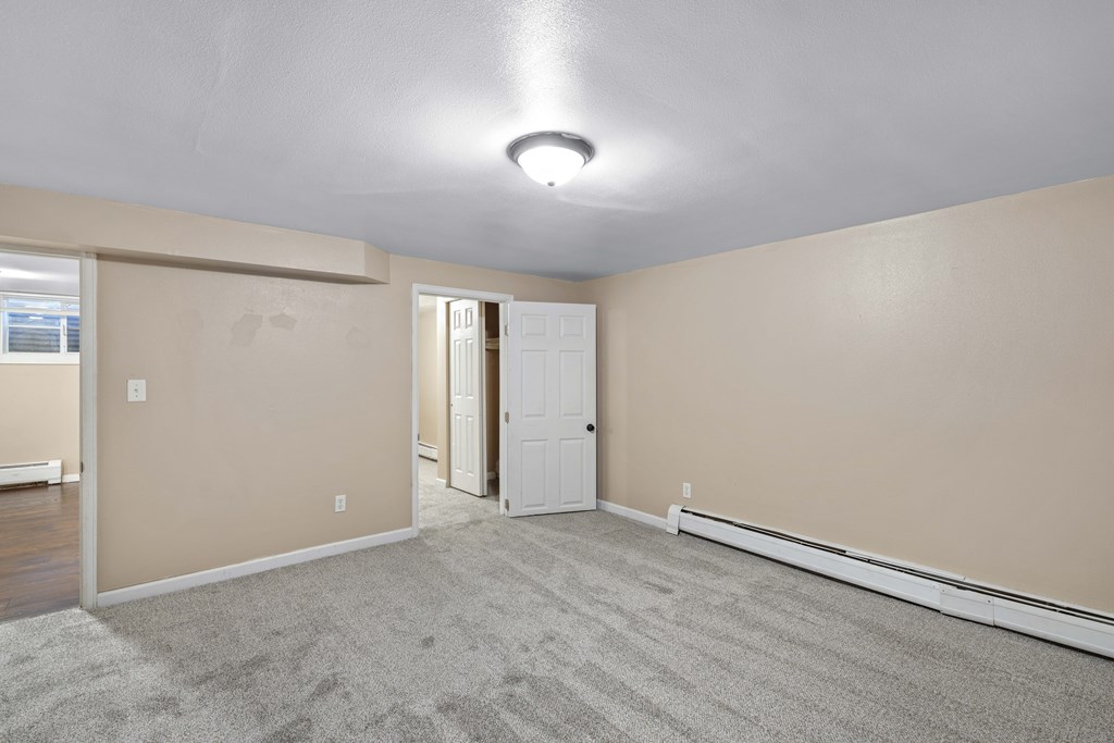 A room with a carpeted floor and a white door.